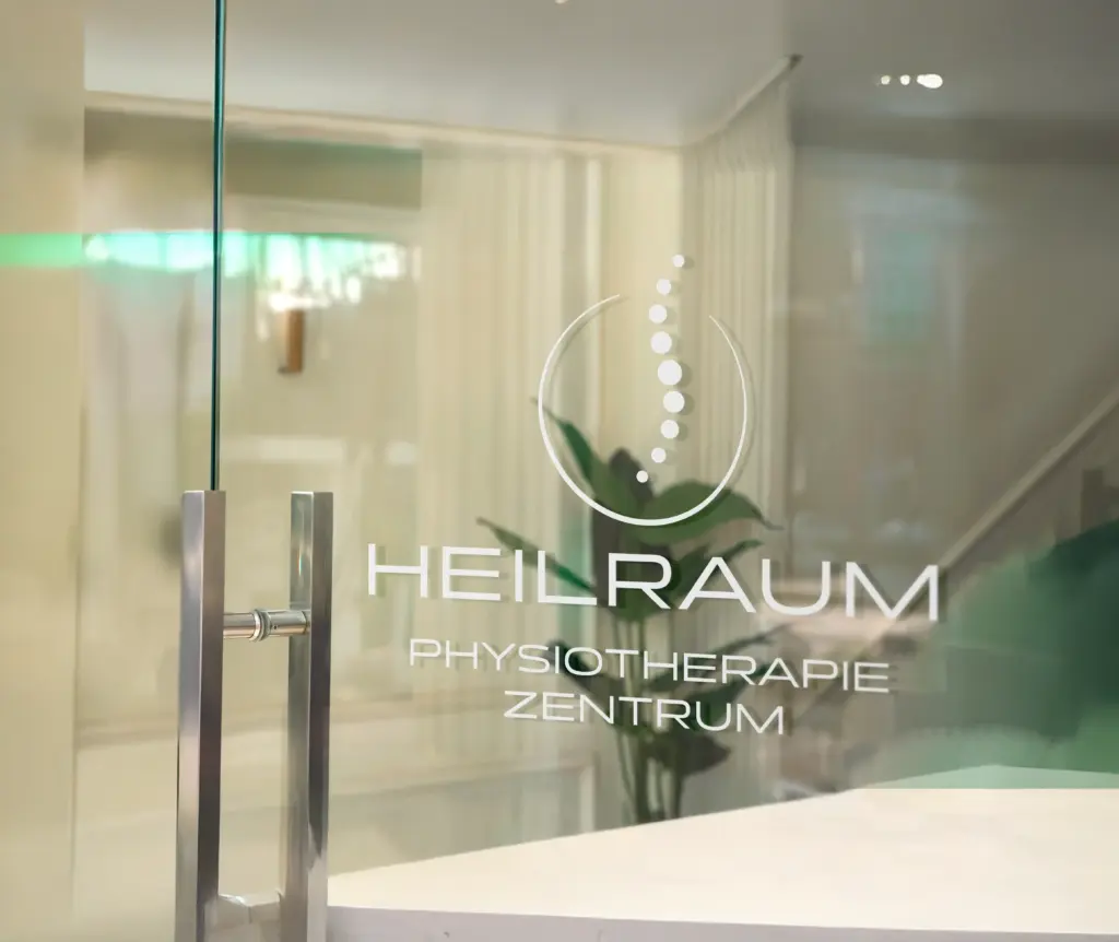 Empfangsbereich einer Physiotherapiepraxis mit Markenlogo auf Glas